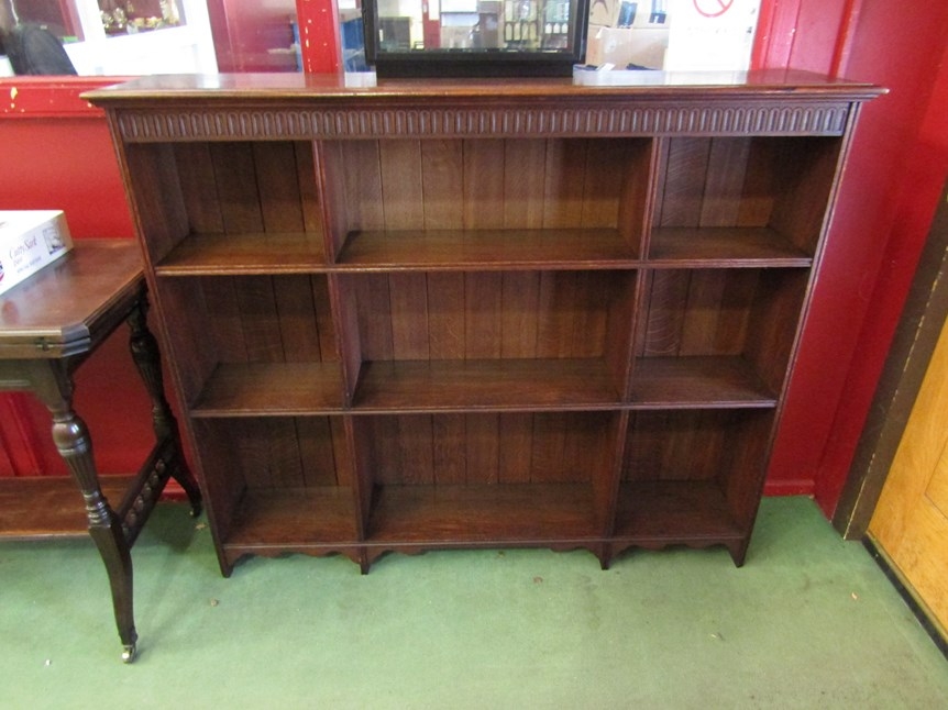 Circa 1900 an Arts and Crafts Oak nine division bookshelf with carved frieze over a reeded edge