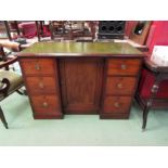 Circa 1860 a mahogany breakfront desk, the gilt tooled leather inset writing surface over six
