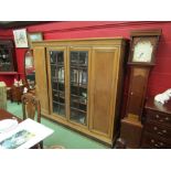 An early 20th Century German oak four door oak bookcase with central glazed doors, flanked by
