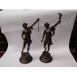 A pair of bronzed metal figures (one lacking flame) signed 'Roussero' to base