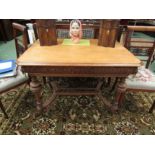 A late Victorian oak table probably "Maples & Co" the canted corner top on a carved dragon frieze