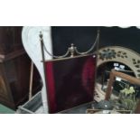 A Regency style brass fireguard with urn and swag cranberry glass panel