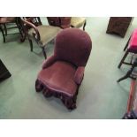 A Victorian chocolate brown upholstered nursing chair on turned legs