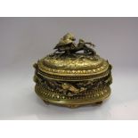 A cast brass lidded pot with hunting scenes of dogs chasing hares, a stork with fish etc. Signed