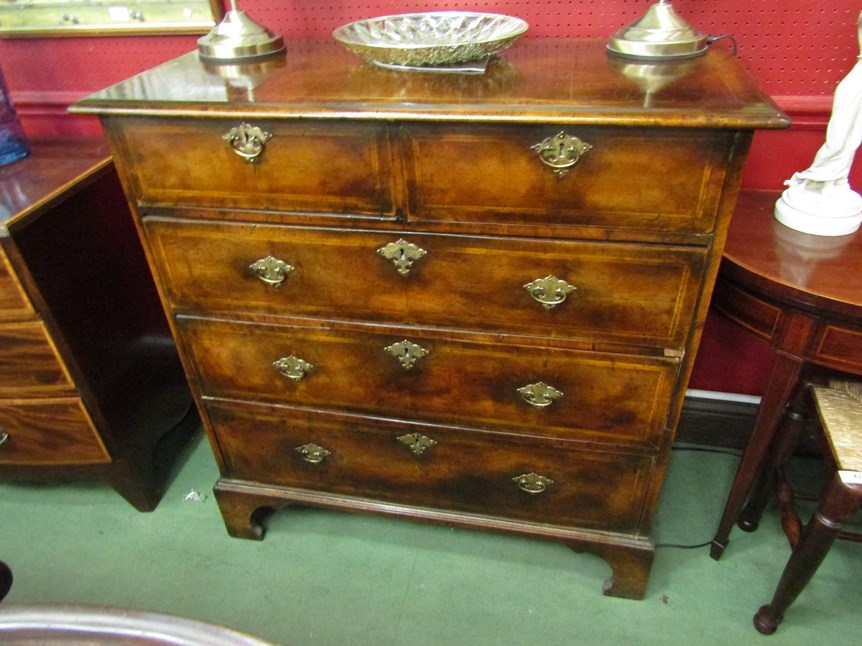 An 18th century walnut chest of two short over three long drawers with quarter veneer top and