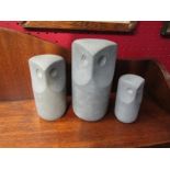 A set of three graduated stone effect owl figures