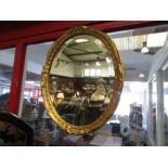 A gilt framed bevel edged mirror of oval form