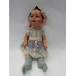 A 1930's composition jointed doll in original pink and blue dress