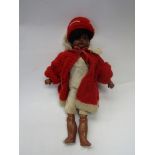 An early 20th Century Black bisque head girl doll on jointed composition body in chamois shirt and