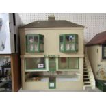 A handmade 1950's fully furnished two storey dolls house as 'Elizabeth' bakery with tearoom above (