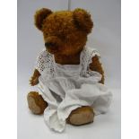 A 1930's/40's straw filled golden mohair jointed bear in the style of Bernard Hermann with glass