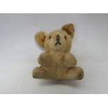 A 1930's miniature straw filled teddy bear cub with glass eyes and stitched nose and mouth, 7cm tall