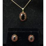A 9ct gold garnet cluster pendant hung on 9ct gold chain, with a pair of matching earrings, 7.6g