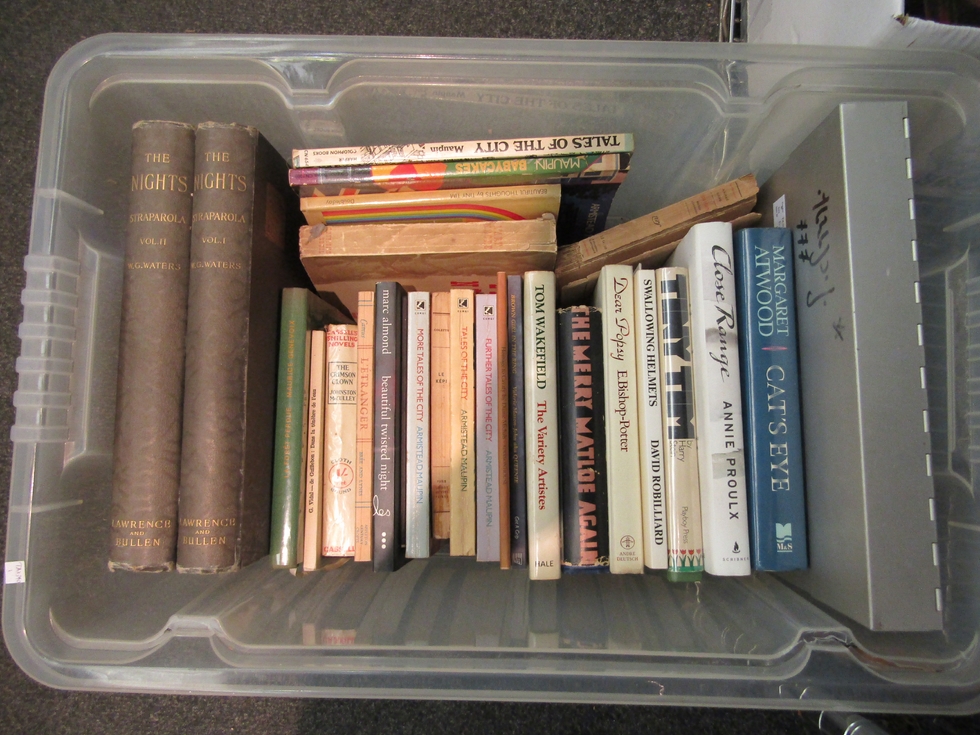 A box of mxied literature, including Margaret Atwood, Annie Proulx, Albert Camus, Armistead Maupin
