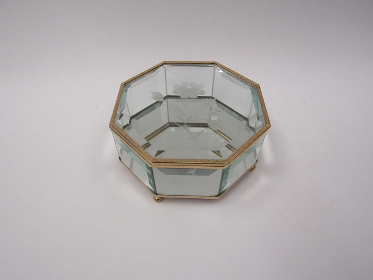 A mirrored bevelled glass jewellery box on metal feet, 14cm diameter