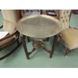 An Islamic folding table with script and brass animal design circular tray top, with tray to