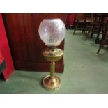 A brass oil lamp, ridged base embossed reservoir, etched glass shade, no chimney, 52cm tall