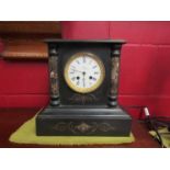 A slate and marble mantel clock with Roman numeral dial