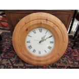 A Bridewell Clocks wall clock with pine surround, 48cm diameter