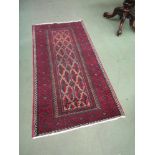 An Eastern red ground geometric design rug, 170 x 85cm