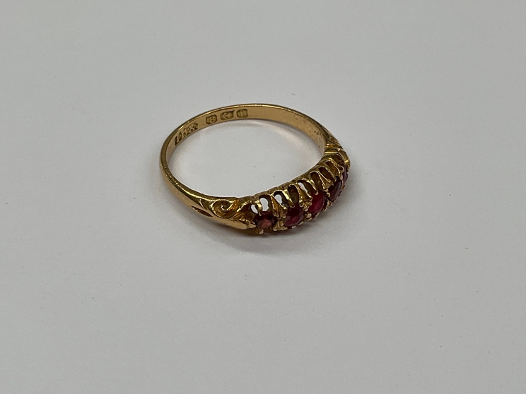 An 18ct gold five stone ruby ring, size N, 2.6g