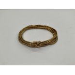 An 18ct gold seven strand bracelet, 48.7g