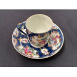 A Worcester coffee cup and saucer decorated in exotic birds, enriched in gilt against a blue mottled