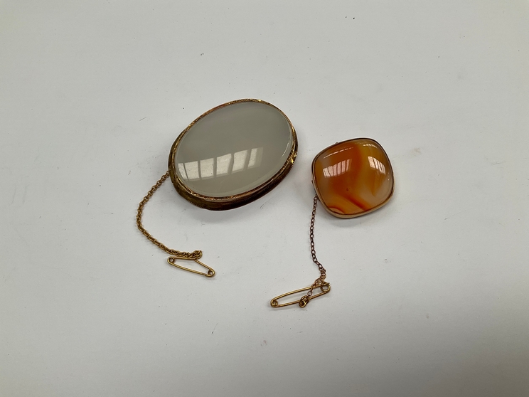 An Agate brooch of rounded rectangular form and an oval white agate brooch