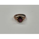 A 9ct gold engraved ring with oval garnet set in claw mount, repaired, size P, 3.9g
