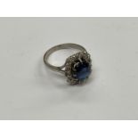 A sapphire and diamond ring, the central sapphire 9mm x 7mm, framed by 16 round cut diamonds,