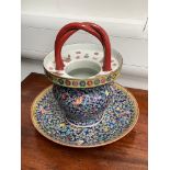 A Chinese vessel with twisted handle over a flat flared rim, all over decoration of flowers and