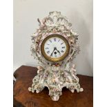 A late 19th Century highly ornate ceramic mantel clock decorated in the Rococo style with putti