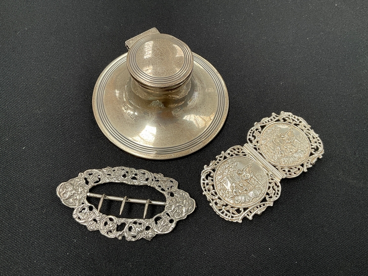 A silver capstan inkwell and two silver buckles (3)