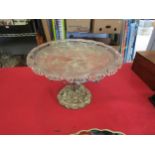 An ornate white metal centrepiece with glass dish, tree with fruiting branch form