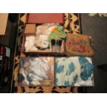 A vintage suitcase with contents including lace oddments, tapestry bag, wooden fans, silk scarf,