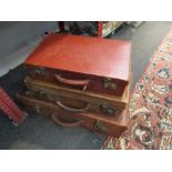 Three vintage leather suitcases