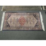 A Belgian blue ground rug with tasselled ends, 158cm x 82cm