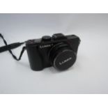 A Panasonic Lumix DMC-LXS digital camera with manual and accessories
