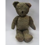 A large straw filled jointed Teddy bear for restoration, head detached (approximately 70cm tall)
