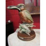 A resin figure of a kingfisher with catch, signed on a wooden plinth, 33cm high