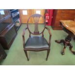 An Edwardian mahogany carved splayed back elbow chair with tapering fore legs to spade feet, a/f