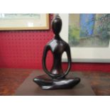 A black abstract sculpture of a female doing yoga, Lotus pose, 20cm tall