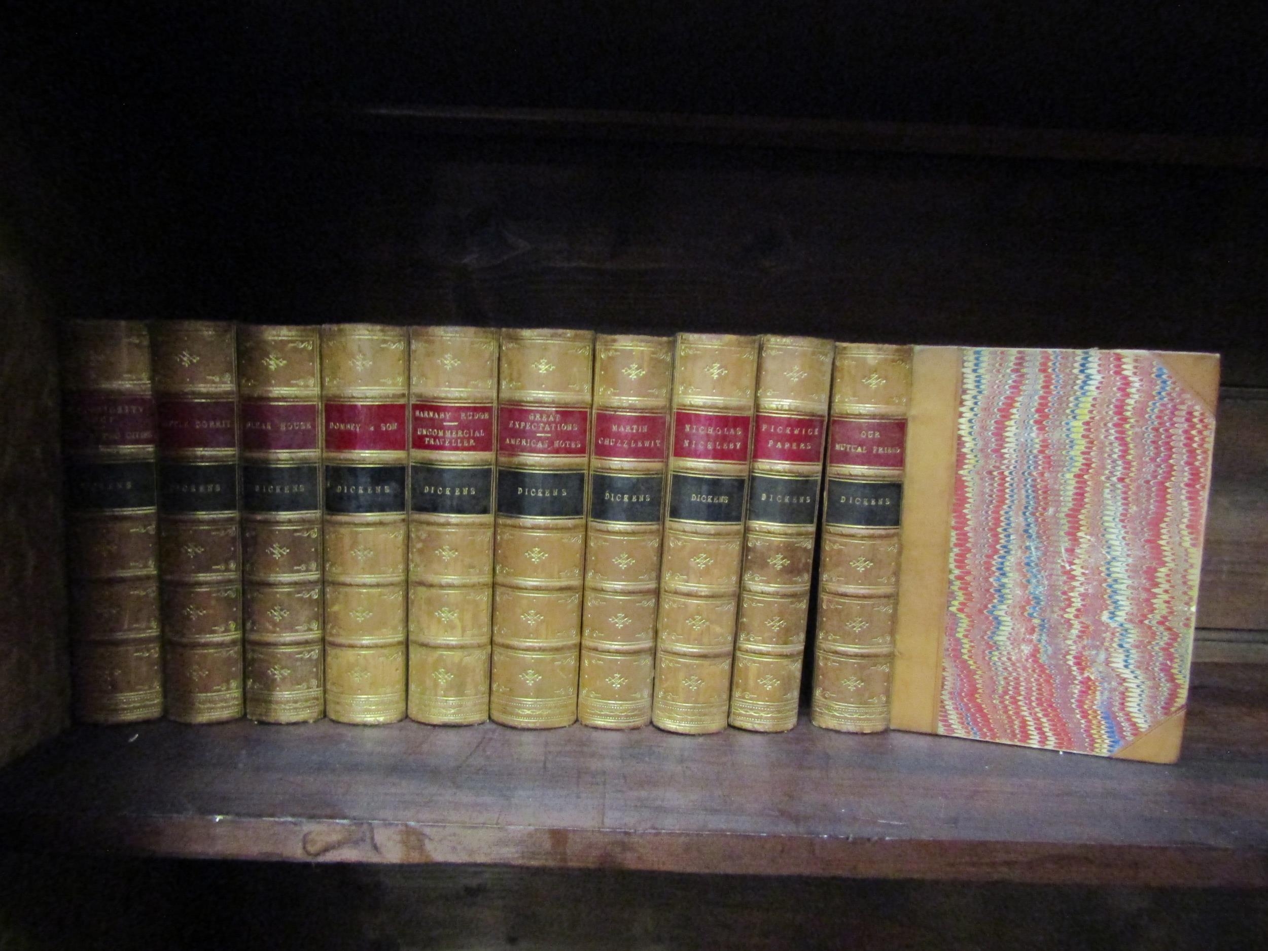 A collection of leather bound Charles Dickens novels with marbled edges and gilt lettering,