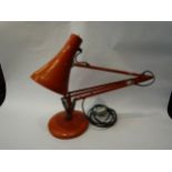 An Anglepoise lamp in orange, on circular base, a/f missing parts