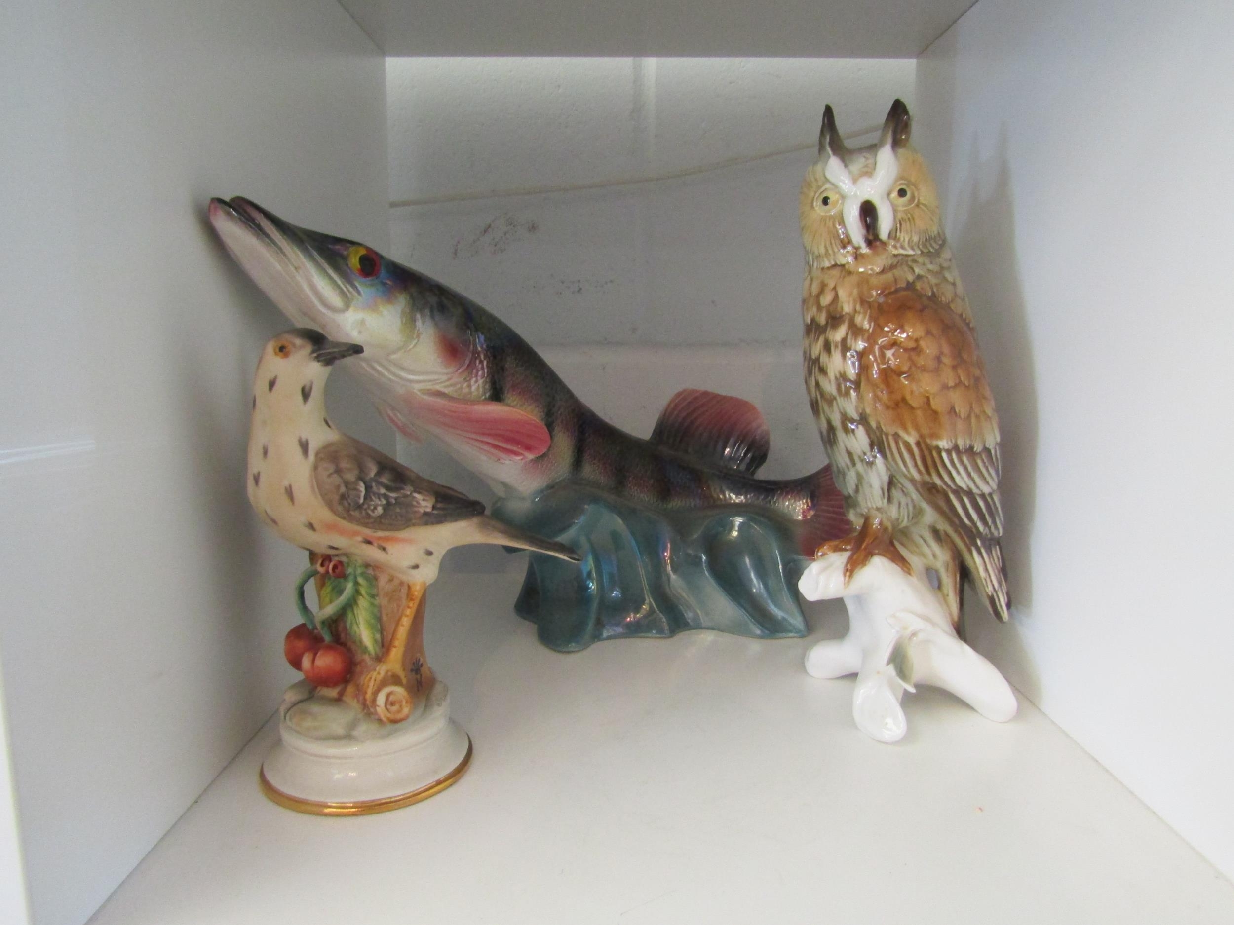 An iridescent ceramic figure of a pike 39cm long, a ceramic figure of an owl on branch 26cm tall and