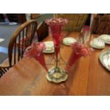 An early 20th Century plated table epergne with four cranberry trumpets. Inscription to base