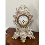 A late 19th Century highly ornate ceramic mantel clock decorated in the Rococo style with putti