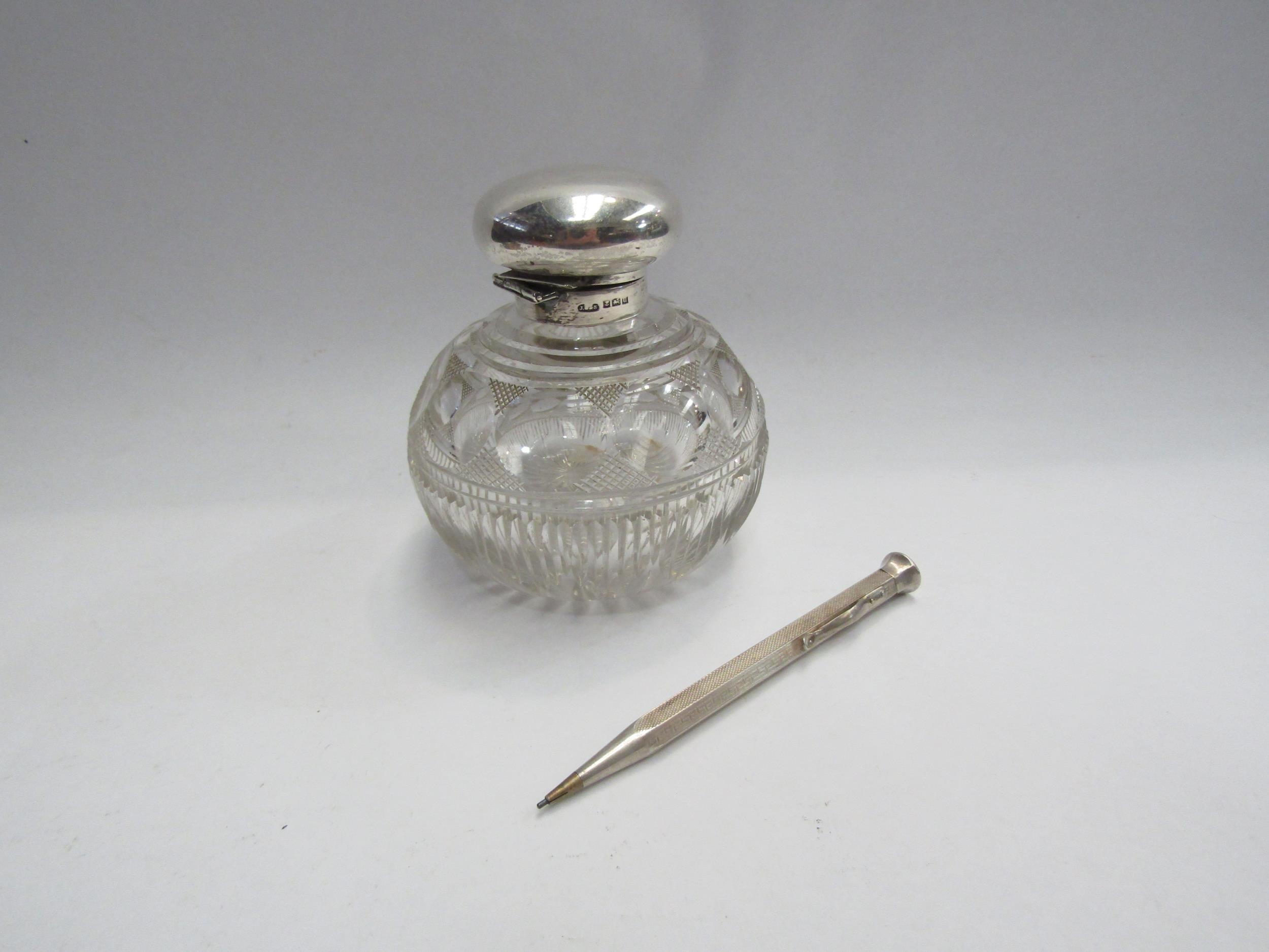 A silver topped glass scent bottle, loose lid and a pencil stamped 900