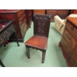 Circa 1860 a carved oak hall chair on bobbin turned fore legs