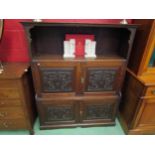 An oak hall cupboard with carved Green Man panels. Shelved interior to cupboard doors. 121cm wide